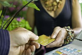 一名女子将她的信用卡递给收银员