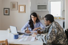 一名士兵和他的妻子在厨房里审阅财务文件