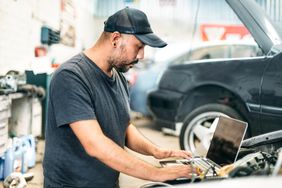 汽车修理工在汽车修理厂使用电脑