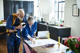 Retired couple planning a cross-country vacation in their kitchen