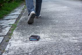 Person walking away from wallet they accidentally dropped